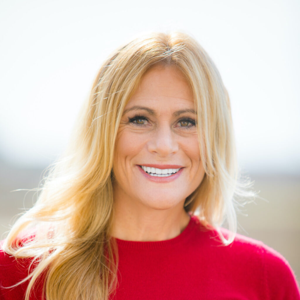 Robyn Benincasa portrait Headshot. She is smiling and wearing a red shirt.