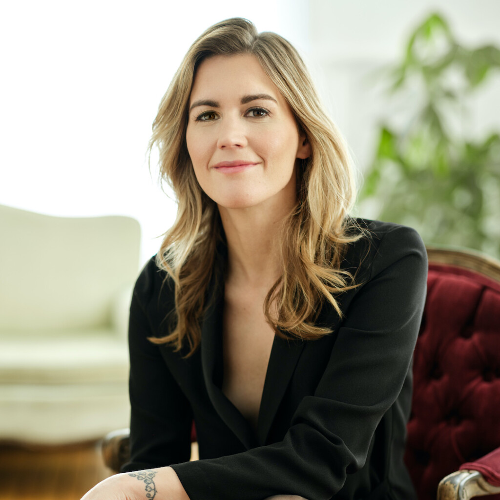 Professional headshot of Emily O'Brien, founder of Comeback Snacks. She is smiling and wearing a black blazer jacket.