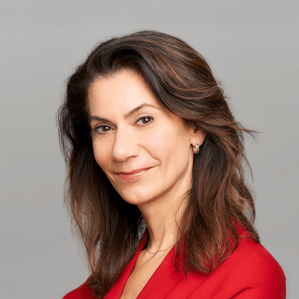 Cecily Sommers. Headshot of Cecily Sommers wearing a red top and posing in front of a grey background.