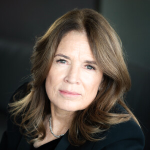 Dr. Dana Sinclair close up headshot in front of a blurred out black background.